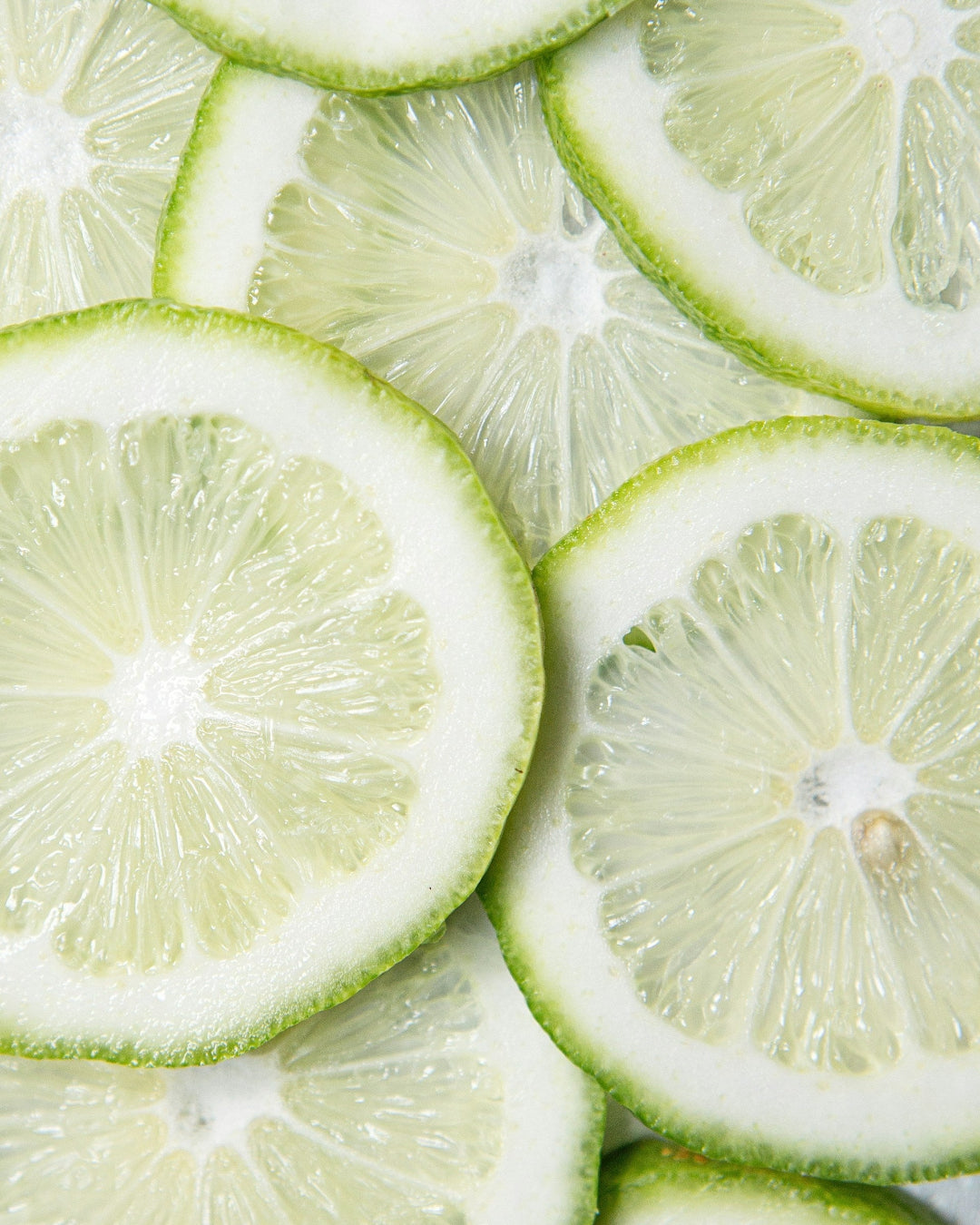 Billedet viser skiver af citrusfrugter der illustrerer de kraftige frugtsyrer der findes i Skin Primers Glycolic Acid: Professionel AHA peeling med glykolsyre, citronsyre og vinsyre. Reducerer rynker, pigmentforstyrrelser og forbedrer hudens glød.