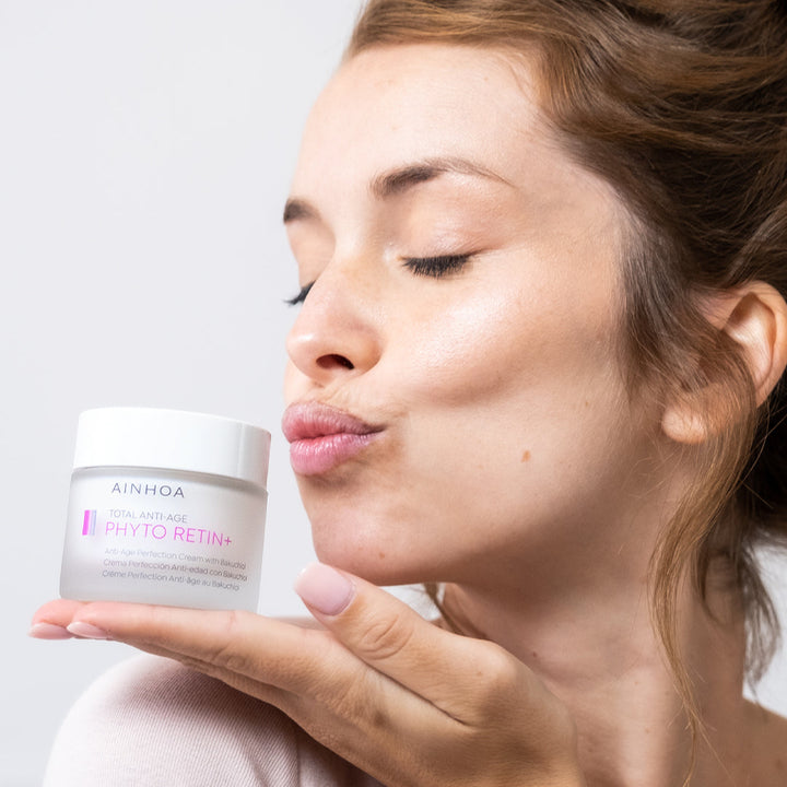 Billedet viser en glad kvinde der kysser hendes  Ainhoa PHYTO RETIN+ Anti Age Perfection Cream: Vegansk dag- og natcreme med bakuchiol. Reducerer rynker, opstrammer huden og giver fornyet glød.