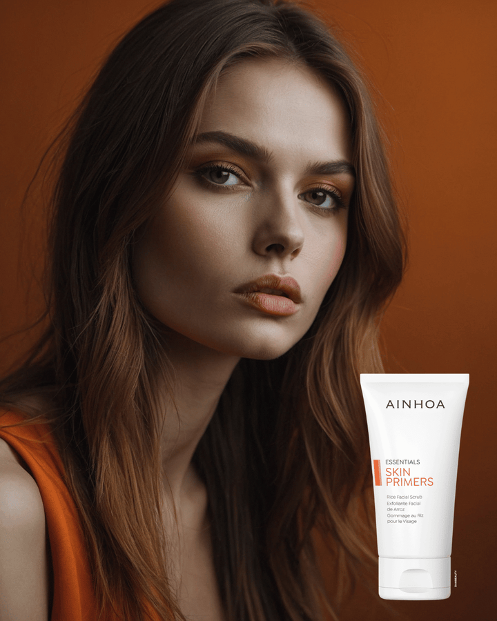 Kvindeansigt og Ainhoa Skin Primers Rice Facial Scrub: Mekanisk peeling for glat, ren og fornyet hud. Klinisk testet. Fjerner urenheder, forbedrer absorption.