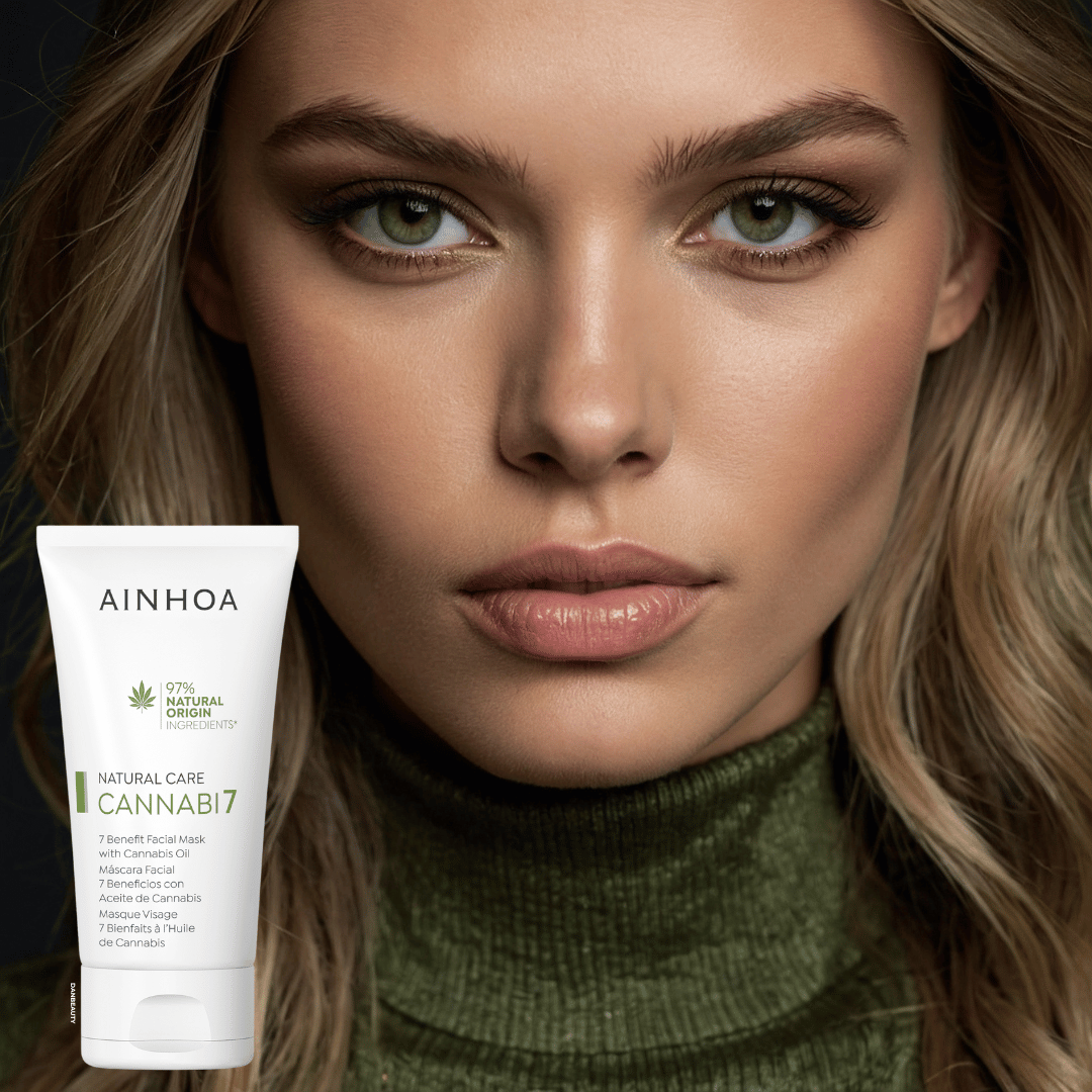 Billedet viser en et smukt kvindeansigt i baggrunden og i forgrunden ses det veganske hudplejeprodukt CANNABI7 - 7 BENEFIT FACIAL MASK WITH CANNABIS OIL fra Ainhoa Brand